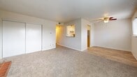 This single-floor, two-bedroom, two-bathroom unit in Riverside, Missouri offers a functional and well-organized layout. The living room serves as the focal point of the space, featuring a brick wood-burning fireplace with decorative iron doors, neutral carpeting, and a window fitted with blinds that allows natural light to filter in. A ceiling fan is visible in the adjoining area, which connects seamlessly to the kitchen via a pass-through opening. The kitchen includes white cabinetry, a sink, and hard-surface flooring, providing a practical workspace.

Both bedrooms are carpeted and finished in neutral tones, creating a calm and understated atmosphere. The primary bedroom offers a comfortable amount of space, while the second bedroom features a window with an outdoor view and easy access to the hallway. Sliding closet doors are present in the bedrooms, providing convenient storage. Textured ceilings are consistent throughout the unit.

The two bathrooms differ in configuration: one includes a tiled walk-in shower with sliding glass doors and wood-look flooring, while the other offers a full tub-shower combination with white tile surround. Both bathrooms feature granite-topped vanities and clean, light finishes.