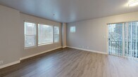 Located at 2901 S 45th St in Tacoma, WA, this three-bedroom, three-bathroom home spans three floors, offering a well-distributed layout with dedicated spaces for living, working, and resting. The ground floor includes an attached garage with drywalled walls, fluorescent lighting, a built-in electrical panel, and an automatic garage door opener — providing ample storage and parking. An entry hallway with tile flooring connects to the upper levels via carpeted staircases with clean white railings. The main living floor features an open kitchen and living room combination. The kitchen stands out with white shaker-style cabinetry, quartz countertops, stainless steel appliances including a refrigerator, dishwasher, and range, plus a wall-mounted range hood and light wood-look flooring. The adjacent living area is bright with multiple windows allowing natural light to fill the space, complemented by neutral-toned wood-look floors. A dedicated den adds flexible space for a home office or additional lounge area. The upper floor hosts the bedrooms, each with soft carpet and closets — the primary bedroom features a double sliding-door closet. Three full bathrooms, each with tub-shower combinations and tile flooring, serve all three floors. Four closets throughout ensure generous storage.