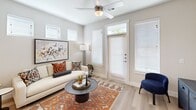 This single-floor residence is designed with a clean, contemporary aesthetic that balances functionality and comfort. The kitchen serves as a central highlight, featuring white shaker-style cabinetry extending to the ceiling, dark granite countertops, stainless steel appliances including a refrigerator, gas range, and microwave, and a kitchen island with an undermount sink illuminated by globe pendant lighting. Light wood-look flooring runs throughout, tying the spaces together seamlessly.

The open layout connects the kitchen directly to the living area, which benefits from multiple windows and a ceiling fan that enhance airflow and natural light. A full-light entry door further brightens the space. The living room offers a relaxed, inviting atmosphere with neutral wall tones providing a versatile backdrop.

The bedroom is a quiet, comfortable retreat featuring a ceiling fan, a window with blinds and drape panels, and direct access to a spacious walk-in closet outfitted with built-in shelving and dual hanging rods. The en-suite bathroom features white cabinetry, dark granite countertops, a large vanity mirror, and wood-look flooring, with the walk-in closet conveniently accessible from within.