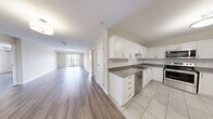 Located at 220 Ira Needles Blvd in Kitchener, Ontario, this well-appointed 2-bedroom, 2-bathroom unit offers a thoughtfully designed layout with modern finishes throughout. The open-concept kitchen and living area serves as the heart of the home, featuring light hardwood-style flooring, crisp white shaker cabinetry, subway tile backsplash, and a full suite of stainless steel appliances. A sliding glass door from the living room leads to a private balcony, offering expansive views of the surrounding Kitchener cityscape and lush greenery beyond.

Both bedrooms are generously sized, bathed in natural light through large windows that frame scenic outdoor views. Each bedroom is complemented by a dedicated walk-in closet with wire shelving systems, providing ample storage. The two bathrooms are finished with light tile flooring and clean, neutral tones — one featuring a stand-up shower stall. A dedicated in-unit laundry room with a full-size washer and dryer adds everyday convenience. Throughout the unit, neutral warm-beige walls and light flooring create a bright, cohesive ambiance that is both welcoming and move-in ready.