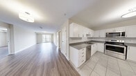 Located at 220 Ira Needles Blvd in Kitchener, Ontario, this well-appointed 2-bedroom, 2-bathroom unit offers a thoughtfully designed layout with modern finishes throughout. The open-concept kitchen and living area serves as the heart of the home, featuring light hardwood-style flooring, crisp white shaker cabinetry, subway tile backsplash, and a full suite of stainless steel appliances. A sliding glass door from the living room leads to a private balcony, offering expansive views of the surrounding Kitchener cityscape and lush greenery beyond.

Both bedrooms are generously sized, bathed in natural light through large windows that frame scenic outdoor views. Each bedroom is complemented by a dedicated walk-in closet with wire shelving systems, providing ample storage. The two bathrooms are finished with light tile flooring and clean, neutral tones — one featuring a stand-up shower stall. A dedicated in-unit laundry room with a full-size washer and dryer adds everyday convenience. Throughout the unit, neutral warm-beige walls and light flooring create a bright, cohesive ambiance that is both welcoming and move-in ready.