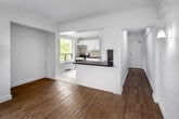 Located at 869 Avenue Rd in Toronto's desirable midtown neighbourhood, this well-appointed one-bedroom, one-bathroom suite offers a clean, modern aesthetic with thoughtful details throughout. The open-concept kitchen and living area serves as the heart of the home, featuring white shaker cabinetry, dark granite countertops, a neutral tile floor, stainless steel appliances including a full-size refrigerator and range, and recessed lighting. Large windows flood the space with natural light and frame lush tree canopy views, creating a bright and airy atmosphere. The living area extends comfortably, showcasing warm hardwood flooring, a wall of corner windows, and a dedicated nook ideal for a dining or office setup. The bedroom is a serene retreat with hardwood floors, a generously sized window overlooking greenery, and a built-in mirrored sliding-door closet offering ample storage. The bathroom is finished with full-height neutral tile, a soaker tub with overhead shower, a pedestal sink, a mirrored medicine cabinet, and a recessed ceiling light. A connecting hallway ties the layout together efficiently. Throughout the suite, crisp white walls, natural light, and tree-lined views contribute to a calm, inviting ambiance.