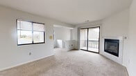 Located on Swaying Pine Court in Miamisburg, Ohio, this two-story residence offers a thoughtfully laid-out 1-bedroom, 1-bathroom floor plan spread across two floors. The main living level hosts a bright, open living and dining area carpeted in neutral tones and filled with natural light from multiple windows with blinds. A standout feature of the living room is the marble-surround fireplace, paired with sliding glass doors that open directly onto a private balcony overlooking the surrounding neighborhood. The galley-style kitchen is efficiently designed with warm oak cabinetry, granite-look countertops, black appliances including a range, microwave, and refrigerator, and hardwood-style flooring, all illuminated by track lighting overhead. The spacious bedroom offers plush carpeting, a generous closet with sliding doors, and a window with natural views. The full bathroom features oak cabinetry, a granite-look vanity top, hardwood-style flooring, and a mirror above the sink. Carpeted staircases connect the entry level to the main living floor, with additional closets providing ample storage throughout. A utility room and hallway round out the functional layout, making this a well-organized and comfortable home.