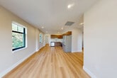 Located in Cazenovia, NY, this thoughtfully designed 2-bedroom, 2-bathroom residence offers a clean, contemporary aesthetic throughout. Light hardwood flooring flows seamlessly across the entire unit, complementing the warm, neutral-toned walls and crisp white trim that define each room.

The open kitchen and living area serves as the heart of the home, showcasing rich walnut-toned cabinetry that extends to the ceiling for generous storage. A textured tile backsplash adds visual interest behind the stainless steel appliances, which include a refrigerator, range, microwave, and dishwasher. White quartz countertops and a deep undermount sink complete the polished kitchen design.

Both bedrooms are bright and well-proportioned, featuring dark-framed windows that frame views of Cazenovia's tree-lined streetscape and neighboring architecture. Recessed lighting and ample natural light give each bedroom an airy, open feel.

The two bathrooms are finished with speckled terrazzo-style tile flooring and clean white fixtures. The full bath includes a tub-shower combination with white tile surround and a warm wood-toned vanity with a white countertop, while the second bath is efficiently appointed.

A hallway with dedicated closet space adds practical storage. The overall design is modern, cohesive, and move-in ready.