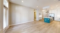 This well-appointed 2-bedroom, 2-bathroom unit in Decatur, GA offers a thoughtfully designed single-floor layout with modern finishes throughout. The open-concept kitchen and living area serves as the heart of the home, featuring light hardwood-style flooring, recessed lighting, and a door leading to a private balcony with outdoor views. The kitchen stands out with white shaker cabinetry, a contrasting teal island with white quartz countertops, a deep undermount sink with a matte black faucet, stainless steel appliances, and stylish pendant lighting. The spacious living area flows seamlessly from the kitchen, bathed in natural light from large windows. Both bedrooms offer plush carpeting and ceiling fans, with the primary bedroom providing generous proportions and a walk-in closet with built-in shelving. The primary bathroom is a true highlight, fully clad in elegant marble-look tile from floor to ceiling, featuring a freestanding soaking tub within a glass-enclosed shower area. The second bathroom mirrors the same refined tile aesthetic with a tub-shower combination. Additional conveniences include a dedicated laundry room with full-size washer and dryer, a second walk-in closet, and a connecting hallway that ties the layout together efficiently.