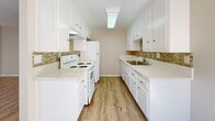 Located at 23930 Ocean Ave in Torrance, California, this single-floor residence offers a clean, well-maintained interior with a thoughtfully designed open layout. Throughout the space, light-toned wood-style flooring provides a warm, cohesive aesthetic that complements the neutral beige walls and white trim found in every room.

The living area is bright and airy, benefiting from natural light streaming through large windows dressed with vertical blinds and a sliding glass door that opens directly to a private outdoor patio. A ceiling fan adds to the comfort of the living space, which flows seamlessly toward the kitchen.

The galley-style kitchen is efficiently laid out with ample white cabinetry on both sides, light quartz-style countertops, a mosaic tile backsplash in warm earth tones, a stainless steel sink, and white appliances including a range and refrigerator. Overhead fluorescent lighting keeps the kitchen well-illuminated.

The bedroom is generously proportioned, offering a wall of mirrored sliding closet doors that enhance the sense of space and provide abundant storage. A bathroom is directly accessible from the bedroom area, and textured ceilings are consistent throughout the unit. The overall ambiance is clean, neutral, and move-in ready.