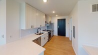 Located at 2823 S Wayzata Blvd in Minneapolis, MN, this single-floor unit offers a thoughtfully designed and modern living space. The open layout is illuminated by large windows that invite abundant natural light and frame pleasant views of mature trees, creating an airy and welcoming atmosphere. Light wood-tone flooring flows throughout, complementing the clean white walls and contemporary finishes.

The kitchen is a standout feature, outfitted with white shaker-style cabinetry, quartz countertops, a herringbone tile backsplash, and a full suite of stainless steel appliances including a range with a stainless hood, dishwasher, and refrigerator. Black hardware accents throughout the kitchen add a modern, cohesive touch.

The living area is equipped with a ceiling fan and a wall-mounted HVAC unit, ensuring year-round comfort. In-unit stacked laundry is conveniently tucked within the layout, adding to the overall functionality of the space.

The bathroom is finished with warm wood-tone cabinetry, a white quartz vanity top, black hardware details, and a full tub and shower surround with classic subway tile. Light wood flooring extends into the bathroom, maintaining a consistent and polished aesthetic throughout the unit.