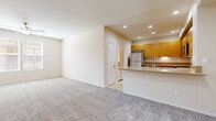 Located at 80175 Avenue 52 in La Quinta, California, this well-appointed single-story residence offers a thoughtfully designed one-bedroom, one-bathroom layout across a comfortable footprint. The open-concept living and dining area features neutral-toned carpet and recessed lighting, creating a bright and welcoming atmosphere. The kitchen seamlessly adjoins the living space via a peninsula breakfast bar with granite-style countertops, and is outfitted with warm honey-toned wood cabinetry, stainless steel appliances including a gas range, over-the-range microwave, and refrigerator, along with tile flooring for easy maintenance. The spacious primary bedroom is bathed in natural light from large windows fitted with horizontal blinds, and includes a ceiling fan for year-round comfort. A generously sized walk-in closet with built-in shelving provides ample storage. The full bathroom features a tub and shower combination, granite-style countertops, and hardwood-style flooring, giving it a clean, functional finish. A hallway connects all areas of the residence efficiently. The overall design palette of soft neutrals and warm wood tones lends the home a calm and cohesive aesthetic, well-suited to comfortable everyday living in the Coachella Valley.