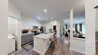 Located at 240 Ivy Meadow Ln in Durham, NC, this single-floor, 2-bedroom, 2-bathroom residence offers a thoughtfully designed open-concept layout. The kitchen serves as a central hub, showcasing granite countertop surfaces, a large island with bar seating, white upper cabinetry, gray lower cabinetry, stainless steel appliances, and a subway tile backsplash. The island flows naturally into the dining area and living room, creating a cohesive and connected communal space. The living room is bright and airy, highlighted by sliding glass doors that open to a private outdoor area, allowing natural light to fill the space. Both bedrooms offer a calm retreat with wood-style flooring, natural light from well-positioned windows, and generous closet storage featuring wire shelving systems. The primary bedroom includes a walk-in closet. Each bathroom is finished with granite vanity countertops, gray cabinetry, and a tiled tub-shower combination. A dedicated in-unit laundry room with a full-size washer and dryer adds everyday convenience. A pantry and hallway complete this functional and cohesive floor plan, all finished with consistent wood-style flooring throughout.