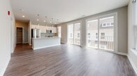 Located at 483–499 Westport St in Norfolk, Virginia, this single-floor unit offers a thoughtfully designed open-concept layout that seamlessly connects the living and kitchen areas. The expansive living space is finished with wide-plank hardwood-style flooring and neutral-toned walls, creating a bright and welcoming atmosphere. Large sliding glass doors flood the area with natural light and provide views of the surrounding neighborhood.

The kitchen is a standout feature, equipped with crisp white cabinetry, light granite countertops, and a full suite of stainless steel appliances including a range, over-the-range microwave, and French door refrigerator. A central island with pendant lighting adds both functionality and style, making it an ideal space for cooking and entertaining.

The bedrooms are carpeted for comfort and feature neutral gray walls, ample natural light from windows with blinds, and generous closet space. The unit includes two bathrooms: one with a sleek glass-enclosed walk-in shower and the other with a full soaking tub and tiled surround, both finished with wood-look flooring and clean white fixtures.

Throughout the unit, consistent design choices — including modern hardware, recessed lighting, and a cohesive neutral palette — contribute to a polished, contemporary feel.
