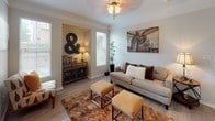 This single-floor residence offers a thoughtfully designed layout that balances comfort and functionality across several well-defined living spaces. The living room serves as the heart of the home, featuring light wood-style flooring, crown molding, a ceiling fan, and multiple windows dressed with white blinds that invite generous natural light. A built-in niche adds architectural character and display space.

The kitchen is outfitted with white shaker-style cabinetry, granite countertops, a gray subway tile backsplash, and a full suite of stainless steel appliances including a range, microwave, dishwasher, and refrigerator. An adjacent dining area with direct exterior access provides a bright, casual setting for meals.

The bedrooms are carpeted and well-proportioned, each featuring ceiling fans and window treatments. The primary bedroom connects to a vanity area with granite countertops, white cabinetry, and a walk-in closet with built-in shelving. A secondary bathroom echoes the same design language, featuring a granite-topped vanity, white cabinetry, and a shower-tub combination. Throughout the residence, neutral tones and consistent finishes create a cohesive and inviting atmosphere.