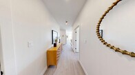 Located at 75 Willow Ct in Boston's Dorchester neighborhood, this thoughtfully designed 2-bedroom, 2-bathroom residence offers a modern aesthetic with clean lines and high-quality finishes throughout its single-floor layout. The open-concept living area is bright and welcoming, featuring light hardwood flooring, recessed lighting, and large windows that fill the space with natural light. The living room offers a comfortable, well-proportioned area that flows seamlessly into the dining space, where oversized windows frame neighborhood views and flood the room with sunlight. The kitchen is outfitted with light wood cabinetry, quartz countertops, a subway tile backsplash, and a full suite of stainless steel appliances, including a French door refrigerator. The primary bedroom is a serene retreat with ample space, natural light from a wide window, and light hardwood floors. The second bedroom mirrors the same bright, airy quality. Both bathrooms feature large-format tile flooring, wood-toned vanities, and matte black fixtures — one with a soaking tub and tiled surround. The overall design is cohesive and contemporary, combining neutral tones, modern hardware, and abundant natural light to create a comfortable and refined living environment.