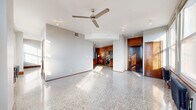 Located in the heart of downtown Tulsa at 427 S Boston Ave, this one-bedroom, one-bathroom residence offers a thoughtfully designed layout across a single floor. Polished terrazzo floors flow seamlessly throughout the entire unit, reflecting natural light and lending a sleek, timeless character to the space.

The open-concept main living area combines the living room, dining room, and kitchen into one cohesive zone. A ceiling fan overhead and large double-hung windows in the living area fill the space with abundant natural light, while a classic cast-iron radiator beneath the windows adds a nod to the building's architectural heritage. The kitchen is well-appointed with rich cherry wood cabinetry featuring frosted glass inserts, dark granite countertops, a full suite of stainless steel appliances — including a refrigerator, range, microwave, and dishwasher — a tile backsplash, and a mobile kitchen island with a granite top for added prep and dining flexibility.

The bedroom is generously proportioned, offering ample space and access to two closets. The bathroom continues the terrazzo flooring and features a dark granite vanity with cherry wood cabinetry. Additional conveniences include an in-unit laundry area and a hallway connecting the private spaces. Solid wood doors with brass hardware are found throughout, reinforcing the unit's warm, upscale urban aesthetic.