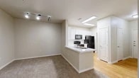 Located at 6216 Crow Ln in Austin, TX 78745, this single-story unit offers a practical, well-organized layout designed for comfortable everyday living. A entry hallway with light wood-look flooring leads into the main living and kitchen areas, providing a clear sense of flow throughout the space.

The kitchen is well-appointed with white shaker-style cabinetry extending to the ceiling, offering generous storage. Black appliances—including a range, microwave, refrigerator, and dishwasher—contrast cleanly against white countertops and a subway tile backsplash. The kitchen opens via a peninsula with a built-in sink toward the living area, which features neutral carpet, track lighting, and a ceiling fan. French doors in the main living space introduce natural light and provide outdoor access.

The bedrooms are carpeted and finished in soft neutral tones, offering quiet, flexible spaces. Two full bathrooms each include a tiled tub-shower combination, tile flooring, and vanity with storage. A dedicated in-unit laundry closet houses a front-loading washer and dryer with overhead wire shelving. Throughout the space, consistent neutral wall tones and clean white trim create a cohesive, understated aesthetic.