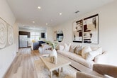 Located in Denver's 80249 neighborhood, this three-story townhome offers a thoughtfully designed layout across three distinct levels. The entry level provides a versatile flex space ideal for a home office, finished with light hardwood-style flooring and recessed lighting. The main living level serves as the heart of the home, featuring an open-concept layout where a well-appointed kitchen flows seamlessly into the dining and living areas. The kitchen is outfitted with dark wood cabinetry, gleaming white quartz countertops, stainless steel appliances, and a central island — all set atop light hardwood-style floors. The living area is bright and airy, benefiting from large sliding glass doors that open to an outdoor balcony with neighborhood views. The upper level houses both bedrooms, each with plush carpeting and generous closet space. The primary bedroom includes a dedicated walk-in closet. Three full bathrooms serve the home, featuring clean white subway tile, dark wood vanities with white countertops, and light hardwood-style flooring. Throughout the home, crisp white walls, recessed lighting, and a neutral palette create a cohesive, modern ambiance ideal for comfortable city living.
