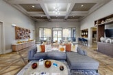 Located at 17802 Mound Rd in Houston, TX, this generously sized single-story community clubhouse offers a thoughtfully designed layout across a broad and open floor plan. The grand lounge area serves as the centerpiece, showcasing striking coffered ceilings, an elegant geometric-patterned hardwood floor, and large windows that invite abundant natural light. Contemporary pendant and chandelier lighting complement the warm, neutral color palette throughout. A built-in shelving unit and textured wood wall art add refined character to the lounge space.

The leasing office features herringbone-style flooring, natural wood desks, and multiple seating areas bathed in natural light from large windows. A quiet nook with tufted armchairs provides an intimate sitting area with outdoor views. A separate media and lounge room includes a wall-mounted TV, framed artwork, and comfortable seating.

The business center offers workstation seating along a built-in desk, complemented by a casual dining area and pendant lighting with a textured accent wall. A game room with a full-size billiards table and shuffleboard provides additional recreation space.

The fitness center is fully equipped with cardio machines, strength-training equipment, free weights, medicine balls, and resistance machines, all set within a bright, mirror-lined space with large windows and ceiling fans.