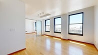 Located on the 9th floor of 541 S Spring Street in the heart of Downtown Los Angeles, this one-bedroom, one-bathroom unit offers an efficient and well-appointed layout with a clean, modern aesthetic. The open living area is bathed in natural light through a series of large black-framed windows that frame sweeping views of the Downtown LA skyline and surrounding cityscape. Warm hardwood flooring flows throughout the main living spaces, complementing the bright white walls and creating an inviting ambiance.

The kitchen is thoughtfully designed with granite countertops, light wood cabinetry featuring glass-front upper panels, and stainless steel appliances including a refrigerator, range, microwave, and dishwasher. A tile floor grounds the kitchen area, visually distinguishing it from the living space.

The bedroom is a comfortable retreat, benefiting from its own set of large windows with city views and continuing hardwood floors. A set of sliding mirrored closet doors adds both storage and a sense of depth to the room.

The bathroom is finished with tile flooring and features a tub-shower combination enclosed by sliding glass doors, paired with a vanity and warm-toned countertop. The overall unit presents a cohesive, functional living environment in a prime Downtown Los Angeles location.