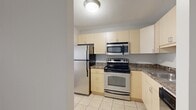 Located at 1212 S Michigan Ave in Chicago's vibrant Grant Park corridor, this one-bedroom, one-bathroom residence offers a practical and well-appointed layout across a single floor. The combined kitchen and living room serves as the heart of the home, where the kitchen features light wood cabinetry, dark granite-style countertops, stainless steel appliances including a refrigerator, electric range, built-in microwave, and dishwasher, as well as a breakfast bar peninsula and tile flooring. The living area transitions to warm hardwood-style flooring and is distinguished by a dramatic curved wall of floor-to-ceiling windows that floods the space with natural light and provides an open, airy ambiance. A wall-unit HVAC system ensures year-round comfort. The bedroom is generously sized, featuring the same hardwood-style flooring, neutral gray walls, a large closet with bi-fold doors, and access to the rest of the unit. The bathroom is clean and functional, offering a tiled tub-shower combination, a vanity with storage, and a medicine cabinet. Throughout, textured ceilings and light gray walls create a cohesive, neutral palette ready for personalization.