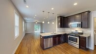 Located at 2775 Stowmarket Ave in Rockford, IL, this single-story home offers a well-designed layout across two bedrooms, two bathrooms, a combined kitchen and living room, a garage, a utility room, and two closets. The living room is bright and spacious, featuring warm hardwood flooring, a ceiling fan, recessed lighting, and a sliding glass door that opens to a wooden deck overlooking a lush, tree-lined backyard — ideal for outdoor relaxation. The kitchen is equipped with rich dark cabinetry, granite countertops, hardwood floors, and stainless steel appliances, creating a functional and stylish cooking space. The primary bedroom is generously sized with plush carpeting, a ceiling fan, and direct access to an en-suite bathroom. The second bedroom also features carpet and a ceiling fan, with ample natural light from a window. Both bathrooms are finished with dark wood vanities and granite countertops; the full bath includes a tub-shower combination and hardwood flooring. Closets are outfitted with wire shelving systems for organized storage. The attached garage is spacious with a concrete floor and automatic opener. The exterior showcases vinyl siding, a back deck, and a sloped green yard bordered by mature trees, offering a peaceful natural setting.