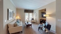 Located at 625 Cameron Walk Ct in Charlotte, NC, this single-floor residence offers a thoughtfully designed layout with a range of functional and stylish living spaces. The kitchen is equipped with white cabinetry, dark granite-style countertops, wood-look flooring, and white appliances including a range, over-the-range microwave, and refrigerator. A corner sink and L-shaped counter configuration maximize workspace and flow. The dining area adjacent to the kitchen features crown molding, a modern pendant light, and a cool blue accent wall that adds a contemporary touch. The living room is warm and inviting, finished with crown molding, plush carpeting, and a built-in niche for media storage. French doors flood the space with natural light and provide outdoor access. The bedrooms are generously proportioned with soft carpeting, large windows dressed with blinds and curtains, and ample closet space. Both bathrooms are finished with white tile flooring, tub-shower combinations, white vanities, and well-lit mirrors. The overall interior palette features neutral warm tones throughout, creating a cohesive and comfortable ambiance suited for everyday living.