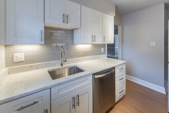 The Cary renovated kitchen with white cabinets, stainless steel appliances and a microwave - Malvern Manor Apartments
