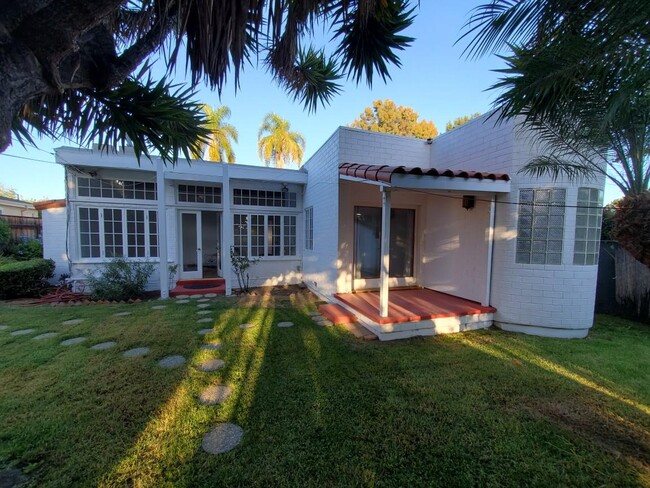 Vista trasera de la casa delantera desde atrás, observe la habitación grande a la izquierda con ventanas de pared a pared - 4231 Chase Ave