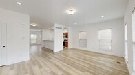 Located at 134 Wellspring Dr in Saint Charles, MO, this three-bedroom, four-bathroom home spans three thoughtfully laid-out floors, offering generous living space throughout. The main level features an open-concept living, dining, and kitchen area united by light-toned hardwood flooring and crisp white walls. A charming arched passageway connects the living area to the kitchen, which is appointed with warm wood cabinetry, stainless steel appliances including a French door refrigerator and over-the-range microwave, and a clean white countertop with a breakfast bar peninsula. Natural light flows in through multiple windows fitted with horizontal blinds. The upper floors house the three bedrooms, including a spacious primary suite, along with well-appointed bathrooms featuring tub-shower combinations. Six closets are distributed throughout, ensuring ample storage. The unfinished basement presents a substantial open canvas, complete with French doors leading outside, concrete walls, and exposed ceiling framing — offering excellent potential for future customization. A patio rounds out the outdoor living options. The home's clean, neutral palette and light hardwood floors create a bright, cohesive aesthetic across all three levels.