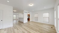 Located at 134 Wellspring Dr in Saint Charles, MO, this three-bedroom, four-bathroom home spans three thoughtfully laid-out floors, offering generous living space throughout. The main level features an open-concept living, dining, and kitchen area united by light-toned hardwood flooring and crisp white walls. A charming arched passageway connects the living area to the kitchen, which is appointed with warm wood cabinetry, stainless steel appliances including a French door refrigerator and over-the-range microwave, and a clean white countertop with a breakfast bar peninsula. Natural light flows in through multiple windows fitted with horizontal blinds. The upper floors house the three bedrooms, including a spacious primary suite, along with well-appointed bathrooms featuring tub-shower combinations. Six closets are distributed throughout, ensuring ample storage. The unfinished basement presents a substantial open canvas, complete with French doors leading outside, concrete walls, and exposed ceiling framing — offering excellent potential for future customization. A patio rounds out the outdoor living options. The home's clean, neutral palette and light hardwood floors create a bright, cohesive aesthetic across all three levels.