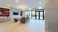 Located at 375 W Whitney Ave in Salt Lake City, UT, this thoughtfully designed single-floor space combines contemporary aesthetics with functional communal living. The open-concept layout seamlessly connects a fully equipped kitchen to a spacious living area, creating an inviting environment for gathering and entertaining.

The kitchen is outfitted with light wood cabinetry, white quartz countertops, a bold deep-blue tile backsplash, stainless steel appliances, and a central island with bar seating — all set against rich crimson accent walls that add warmth and personality.

The living room is anchored by a striking geometric-patterned feature wall with a wall-mounted TV, flanked by built-in shelving with deep maroon accents. A statement gold Sputnik chandelier draws the eye upward, while large floor-to-ceiling black-framed windows and sliding glass doors flood the space with natural light and frame dramatic views of the Salt Lake City skyline and the snow-capped Wasatch Mountains. Light hardwood flooring flows throughout, enhancing the airy, open feel.

Accessible directly from the living area, the expansive rooftop terrace is finished with large-format tile and features raised planters, outdoor seating, and dining areas — all set against panoramic mountain and cityscape views, making it an exceptional outdoor retreat.