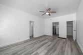 Located at 123 E Windsor Rd in Glendale, CA, this single-floor, one-bedroom, one-bathroom unit offers an efficient and thoughtfully laid-out living space. Light wood-style flooring runs seamlessly throughout, lending a clean, cohesive aesthetic to every room. The living area is bright and open, featuring white walls, a ceiling fan with lighting, and natural light filtering in through a window with views of surrounding greenery — creating an airy, welcoming atmosphere. The space flows naturally into the bedroom, which also features a ceiling fan, a closet with louvered doors, and a window that brings in additional natural light. The kitchen is a standout feature, equipped with rich dark wood cabinetry, a classic white subway tile backsplash, and a full suite of stainless steel appliances including a gas range, over-the-range microwave, and refrigerator. A single sink with ample counter space completes the functional layout. The bathroom is finished in crisp white, featuring a full bathtub with a handheld showerhead and a window that allows natural light and a glimpse of the outdoors. Two closets provide practical storage solutions throughout the unit. The overall design is clean, minimal, and move-in ready.