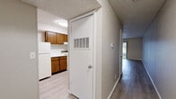 Located at 910 E 61st St S in Tulsa, Oklahoma, this two-bedroom, one-bathroom unit offers a practical and comfortable layout across a single floor. The living room serves as the heart of the home, featuring light-toned luxury vinyl plank flooring, a ceiling fan with light fixture, a textured ceiling, and a striking dark-brick wood-burning fireplace. A sliding glass door floods the space with natural light and provides direct access to an outdoor patio area. The kitchen connects openly to the living area and is outfitted with warm wood-toned cabinetry, light countertops, a range, dishwasher, and refrigerator — all set on matching LVP flooring. A pass-through window between the kitchen and living space enhances the open feel. A central hallway connects the main living areas to the two bedrooms, each carpeted for comfort with neutral wall tones and textured ceilings. The primary bedroom includes an adjacent closet. The full bathroom features a tub/shower combination and light flooring. A dedicated closet provides additional storage. The overall aesthetic is clean and neutral, offering a functional canvas throughout.