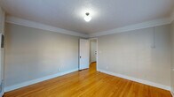 Located in the vibrant Northwest Portland neighborhood, this single-floor unit at 2209 NW Everett St blends classic character with functional design. Throughout the living spaces, warm hardwood floors catch the light beautifully, complemented by crisp white crown molding and textured ceilings that add a touch of timeless charm. Neutral-toned walls provide a clean, versatile backdrop across each room.

The living area features a pair of large windows dressed with white horizontal blinds, allowing generous natural light to filter in while offering views of the surrounding greenery. Baseboard heating units beneath the windows ensure comfort year-round.

The kitchen stands out with its distinctive patterned tile flooring, white cabinetry, and a peninsula unit featuring a charming glass-panel cabinet door — a nod to the building's classic architectural heritage. A window above the counter adds natural light to the workspace.

The bathroom is appointed with full subway tile surrounds in the tub enclosure, accented with dark grout for a crisp, classic look. A frosted window above the soaking tub brings in soft, diffused light while maintaining privacy.

The bedrooms are well-proportioned, featuring the same warm hardwood floors, crown molding, and ceiling fixtures found throughout the unit, creating a cohesive and inviting atmosphere.