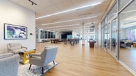 Located at 710 Vikings Pkwy in Eagan, Minnesota, this single-floor amenity space offers a generously sized, thoughtfully designed environment built for socializing, recreation, and relaxation. The open-plan layout is anchored by warm hardwood flooring that flows seamlessly throughout, complemented by crisp white ceilings with linear LED lighting that keeps the entire space bright and inviting.

The main gathering area features a variety of flexible seating arrangements, including upholstered sectional sofas, lounge chairs, high-top bar tables with stools, and banquette-style booth seating with acoustic paneling — accommodating everything from casual conversation to larger group gatherings. Floor-to-ceiling glass partitions line portions of the space, allowing natural light to filter in from the surrounding exterior and creating a sense of openness and connectivity.

A standout feature is the dedicated bowling lounge, complete with full-length lanes, digital scoring screens, and a stylish lounge area furnished with a plush sectional sofa set against a bold geometric accent wall. Adjacent to the main floor, a billiards table and shuffleboard table provide additional entertainment options. Throughout the space, pendant lighting adds visual interest and warmth. Glass-walled rooms along the perimeter offer quieter settings visible from the main floor, rounding out this dynamic and well-appointed recreational destination.