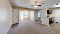 Located at 100 Riverset Lane in Memphis, Tennessee, this single-floor, 1-bedroom, 1-bathroom residence offers a well-organized and functional layout. The open combined kitchen and living area forms the heart of the home, with the living space featuring plush wall-to-wall carpeting, neutral beige walls, a ceiling fan with light fixture, and a textured ceiling. Natural light filters in through multiple windows fitted with blinds, including a front-facing door with an adjacent window that brightens the main living area. The kitchen is appointed with dark espresso cabinetry, light countertops, wood-look vinyl flooring, and black appliances including a range and refrigerator, providing a sleek, functional cooking space. The bedroom is a comfortable, carpeted retreat with a large window offering outdoor views, a dedicated closet, and HVAC floor vents for year-round comfort. The bathroom features a full tiled tub-shower combination with chrome fixtures, wood-look vinyl flooring, and a vanity with storage. Clean white trim and consistent neutral tones throughout the space create a cohesive, move-in-ready feel well suited for those seeking practical, comfortable living in Memphis.