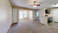 Located at 100 Riverset Lane in Memphis, Tennessee, this single-floor, 1-bedroom, 1-bathroom residence offers a well-organized and functional layout. The open combined kitchen and living area forms the heart of the home, with the living space featuring plush wall-to-wall carpeting, neutral beige walls, a ceiling fan with light fixture, and a textured ceiling. Natural light filters in through multiple windows fitted with blinds, including a front-facing door with an adjacent window that brightens the main living area. The kitchen is appointed with dark espresso cabinetry, light countertops, wood-look vinyl flooring, and black appliances including a range and refrigerator, providing a sleek, functional cooking space. The bedroom is a comfortable, carpeted retreat with a large window offering outdoor views, a dedicated closet, and HVAC floor vents for year-round comfort. The bathroom features a full tiled tub-shower combination with chrome fixtures, wood-look vinyl flooring, and a vanity with storage. Clean white trim and consistent neutral tones throughout the space create a cohesive, move-in-ready feel well suited for those seeking practical, comfortable living in Memphis.
