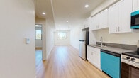 Located on Weddington Street in Los Angeles, CA, this single-floor, one-bedroom, one-bathroom unit offers a thoughtfully designed layout with clean, modern finishes throughout. Light wood flooring flows seamlessly across every room, creating a warm and cohesive aesthetic against the crisp white walls and recessed lighting.

The open living area is bright and airy, benefiting from natural light streaming through black-framed windows that frame views of the surrounding neighborhood greenery. The kitchen is well-equipped, featuring white shaker-style cabinetry with ample upper and lower storage, gray countertops, a stainless steel sink, and a full suite of appliances including a refrigerator, electric range, over-the-range microwave, and dishwasher.

The bedroom is a comfortable, well-proportioned space with a black-framed window offering outdoor views and access to a dedicated closet. The bathroom is clean and functional, appointed with a white vanity topped with a dark countertop, a framed mirror, built-in shelving, and a combination tub and shower enclosed by sliding glass doors. Every detail reflects a modern, move-in-ready design tailored for practical and stylish urban living in the heart of Los Angeles.