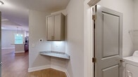 Located at 4531 Langdon Dr in Durham, NC, this well-appointed 2-bedroom, 2-bathroom single-floor home offers a thoughtfully designed layout across a comfortable footprint. The open-concept living, dining, and kitchen area serves as the heart of the home, featuring warm hardwood-style flooring, vaulted ceilings with a ceiling fan, and windows that invite abundant natural light and outdoor views. The kitchen is outfitted with crisp white shaker cabinetry extending to the ceiling, granite countertops, and a full suite of stainless steel appliances including a French door refrigerator, range, and microwave. A dedicated pantry provides additional storage. The primary bedroom is generously sized with plush carpeting, a ceiling fan, and direct access to an en-suite bathroom featuring a walk-in glass-door shower. A spacious walk-in closet with wire shelving completes the suite. The second bedroom also features carpeting and a ceiling fan. The second bathroom includes a tub-shower combination. A dedicated laundry room houses full-size washer and dryer units. Additional highlights include a corner built-in granite shelf with upper cabinetry, a utility room, and a private balcony.