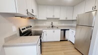 Located at 7535 Windbridge Dr in Sacramento, California, this single-floor, two-bedroom, one-bathroom home offers a well-organized and functional layout. The kitchen is a standout feature, outfitted with crisp white shaker cabinets, light stone countertops, and a full suite of stainless steel appliances including a refrigerator, dishwasher, and electric range. Light wood-style flooring runs throughout the kitchen, which also benefits from a window that brings in natural light and neighborhood views. The living area opens to the outdoors through a sliding glass door dressed with vertical blinds, allowing ample sunlight and providing direct outdoor access. Both bedrooms are carpeted in neutral tones and feature sliding closets with built-in rods for convenient storage. The primary bedroom is a comfortable size with good natural light from a window. The second bedroom also includes a closet and connects easily to the main hallway. The single full bathroom is clean and practical, featuring a combination tub and shower with chrome fixtures and warm wood-style flooring. Neutral wall tones and white trim throughout the home create a cohesive and understated aesthetic, giving each room a clean, move-in-ready feel.