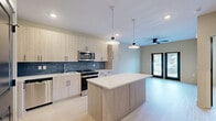 Located at 112 Point Place in Mooresville, NC, this thoughtfully designed single-floor residence offers a seamless blend of modern aesthetics and functional living. The open-concept layout connects the kitchen and living area, creating an inviting, airy atmosphere enhanced by light hardwood flooring throughout.

The kitchen is a standout feature, showcasing light wood cabinetry, a bold blue tile backsplash, stainless steel appliances, and a generous central island with a clean white countertop. Pendant lighting above the island adds a refined touch, while recessed lighting ensures the space is well-lit.

The living area flows naturally from the kitchen and benefits from access to the outdoors through double doors, allowing natural light to fill the room. A ceiling fan overhead adds comfort and practicality.

The bedroom is a comfortable, well-proportioned retreat with large windows fitted with blinds, a ceiling fan, and soft neutral walls that create a calm atmosphere. An adjacent closet provides dedicated storage.

The bathroom is elegantly appointed with a tub-shower combination clad in dramatic marble-style tile featuring warm gold veining, complemented by a frameless sliding glass door and light wood-tone flooring, tying the space together with a sophisticated, contemporary finish.