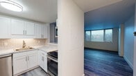 Located at 50 Holy Family Rd in Holyoke, Massachusetts, this thoughtfully renovated single-floor unit offers a clean, modern aesthetic throughout. The kitchen is a standout feature, showcasing crisp white shaker cabinetry, marble-look countertops, a classic subway tile backsplash, and a full suite of stainless steel appliances including a refrigerator, range, microwave, and dishwasher. Light wood-tone luxury vinyl plank flooring runs through the kitchen and living areas, creating a seamless, contemporary flow. A pass-through window connects the kitchen to the living space, enhancing the open feel of the layout. The living room is bright and airy, benefiting from natural light through large windows with outdoor views. Bedrooms are finished with plush carpeting and generous wall space, offering comfortable and quiet retreats. The bathrooms are elegantly appointed with marble-look tile on the floors, walls, and tub surround, complemented by white vanity cabinetry, marble-look countertops, and brushed nickel fixtures and grab bars. Throughout the unit, crisp white walls and clean finishes contribute to a fresh, move-in-ready atmosphere that balances modern style with everyday functionality.
