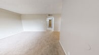 Located at 8401 Spain Rd NE in Albuquerque, New Mexico, this single-floor unit offers four bedrooms, two bathrooms, a living room, and a kitchen within a well-organized and efficient layout. The living room is spacious and open, featuring neutral-toned carpet, soft wall colors, and a hallway that connects the space to the rest of the unit. Natural light flows in through large windows dressed with horizontal blinds, giving the common areas a bright and welcoming feel. The kitchen is a standout feature, designed in a galley style with crisp white shaker cabinetry, light quartz-style countertops, a stainless steel sink, and a full suite of stainless steel appliances including a refrigerator, range, microwave, and dishwasher. Wood-look flooring grounds the kitchen with a clean, modern aesthetic. The bedrooms are carpeted and feature neutral walls, blinds-covered windows that bring in natural light, and ceiling fans for year-round comfort. The generously sized primary bedroom includes two side-by-side closets with built-in hanging rods, offering ample storage. The bathrooms are clean and functional, with one featuring a full tub and shower combination with chrome fixtures and wood-look flooring throughout.