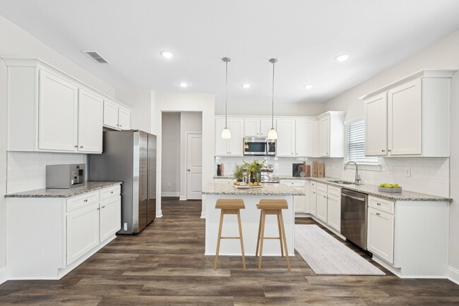 View of the kitchen and entry hallway. Offering bar seating, plenty of cabinet space and granite countertops. - Overlook at Palisades