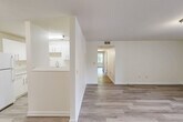 Located in East Ridge, Tennessee, this single-story, 3-bedroom, 2-bathroom home offers a clean, modern interior with a bright and cohesive design throughout. Light-toned luxury vinyl plank flooring runs seamlessly through the living areas and bedrooms, complementing the crisp white walls and creating an airy, welcoming ambiance.

The living room is generously proportioned, filled with natural light from a set of double doors that open to an outdoor view. A hallway connects the living area to the private quarters, maintaining a practical and intuitive layout. The kitchen features white cabinetry, a double-basin sink, white appliances including a full-size refrigerator and dishwasher, and a convenient pass-through window that opens to the living space, enhancing connectivity between rooms.

The spacious primary bedroom includes its own walk-in closet outfitted with dual wire shelving rods, providing ample organized storage. The additional bedrooms are well-sized and include closet access. Two full bathrooms serve the home, one featuring a dark-vanity with a white countertop and a tub-shower combination with a molded surround.

Storage is further supported by two dedicated closets accessible from the hallway. The home's consistent, neutral palette and updated finishes present a move-in-ready environment suitable for a variety of lifestyles.