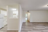 Located in East Ridge, Tennessee, this single-story, 3-bedroom, 2-bathroom home offers a clean, modern interior with a bright and cohesive design throughout. Light-toned luxury vinyl plank flooring runs seamlessly through the living areas and bedrooms, complementing the crisp white walls and creating an airy, welcoming ambiance.

The living room is generously proportioned, filled with natural light from a set of double doors that open to an outdoor view. A hallway connects the living area to the private quarters, maintaining a practical and intuitive layout. The kitchen features white cabinetry, a double-basin sink, white appliances including a full-size refrigerator and dishwasher, and a convenient pass-through window that opens to the living space, enhancing connectivity between rooms.

The spacious primary bedroom includes its own walk-in closet outfitted with dual wire shelving rods, providing ample organized storage. The additional bedrooms are well-sized and include closet access. Two full bathrooms serve the home, one featuring a dark-vanity with a white countertop and a tub-shower combination with a molded surround.

Storage is further supported by two dedicated closets accessible from the hallway. The home's consistent, neutral palette and updated finishes present a move-in-ready environment suitable for a variety of lifestyles.