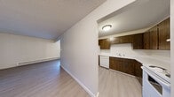 Located at 402 N G St in Tacoma, WA, this 2-bedroom, 1-bathroom unit offers a well-organized single-floor layout designed for comfortable everyday living. The living room features light-toned laminate hardwood flooring, a textured ceiling, and a baseboard heating system, with sliding glass doors that open directly onto a private balcony overlooking lush outdoor greenery. Adjacent to the living area, the dining room benefits from natural light through a large window and is accented by a classic chandelier, creating an inviting atmosphere for meals. The kitchen is equipped with dark wood cabinetry, a full suite of white appliances including a refrigerator, dishwasher, and range, along with light laminate flooring that ties the space together. Both bedrooms offer plush carpeting, textured ceilings, and windows that bring in natural light. The primary bedroom includes a built-in closet with sliding doors for convenient storage. The full bathroom features a combined tub and shower, a single-sink vanity with dark wood cabinetry, a mirrored medicine cabinet, and light hardwood-style flooring. A hallway connects all rooms efficiently, and two closets provide additional storage throughout the unit.