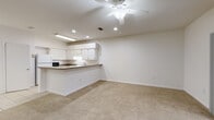 Located at 1609 NW 29th Rd in Gainesville, Florida, this two-story residence offers a well-organized layout across two levels. The main floor welcomes you with light tile flooring in the entryway and hallway, leading to a bright living area with carpet flooring, a ceiling fan, and sliding glass doors that bring in natural light and views of the outdoors. The kitchen is designed in a U-shape with ample white cabinetry, granite-look countertops, a breakfast bar peninsula, tile flooring, recessed lighting, and white appliances including a refrigerator and electric range with overhead ventilation. A dedicated laundry area on the main floor includes a full-size side-by-side washer and dryer with overhead wire shelving for additional storage. The carpeted staircase with a white railing leads to the upper level, where the bedrooms are located. Each bedroom features plush carpet, a ceiling fan, and ample closet space. The bathrooms are finished with tile flooring, a tub-shower combination, and a vanity with countertop. The overall aesthetic is clean and neutral, with white walls and bright recessed lighting throughout, creating a practical and comfortable living environment.