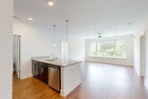 This well-appointed 2-bedroom, 3-bathroom residence at 111 Edgeway Dr in Winston-Salem, NC offers a thoughtfully designed single-floor layout. The open-concept kitchen and living area forms the heart of the home, anchored by a central island with granite countertops, an undermount sink, and stylish pendant lighting. Dark espresso cabinetry contrasts beautifully with the light stone surfaces, while stainless steel appliances—including a refrigerator, range, and microwave—complete the kitchen. Rich hardwood flooring flows throughout the main living areas, and a large multi-pane window in the living room fills the space with natural light and offers views of lush greenery, complemented by a ceiling fan overhead. The primary bedroom is generously sized, featuring hardwood floors, wide windows with tree-lined views, and direct access to a walk-in closet with wire shelving. The second bedroom is finished with plush carpeting, a ceiling fan, and its own outdoor-facing window. Three full bathrooms serve the residence, one of which includes a full soaking tub and shower surround with built-in shelving. A dedicated laundry room with side-by-side washer and dryer adds everyday convenience. Two closets, including a spacious walk-in, provide ample storage throughout.