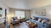 This single-floor unit in Memphis, TN offers a well-organized two-bedroom, one-and-a-half-bathroom layout designed for comfortable everyday living. The living room serves as the heart of the home, featuring durable wood-look flooring, a textured ceiling, and a large window fitted with horizontal blinds that allows generous natural light to fill the space. The room provides ample area for seating arrangements and includes a dedicated media wall for entertainment.

The kitchen is outfitted with white cabinetry offering abundant storage, dark laminate countertops, a full-size electric range, and a full-size refrigerator, all set on wood-look flooring that continues from the main living area.

Both bedrooms feature plush carpeting and ceiling fans with integrated lighting. The primary bedroom includes a closet and a window for natural light, while the second bedroom offers flexible space suitable for various configurations. Each room provides sufficient space for standard bedroom furnishings.

The full bathroom includes a tub-shower combination, a vanity with storage, and wood-look flooring. The half bathroom offers a single vanity and toilet, conveniently accessible from the main living areas.