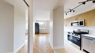 Located at 331 Metcalfe St in Ottawa's vibrant Centretown neighbourhood, this well-appointed three-bedroom, one-bathroom unit offers a thoughtfully designed single-floor layout. Classic parquet wood flooring flows throughout the living areas and bedrooms, lending warmth and character to the space.

The modern kitchen has been renovated to a high standard, featuring warm wood upper cabinetry, crisp white lower cabinets, a white quartz countertop, and a full suite of stainless steel appliances including a range, over-the-range microwave, dishwasher, and refrigerator. Light tile flooring and a contemporary pendant light fixture complete the kitchen's clean, functional aesthetic.

The generously sized primary bedroom receives abundant natural light through large windows that frame views of the surrounding neighbourhood's mature trees and rooftops. The additional bedrooms are equally well-lit, each featuring large windows with baseboard heating beneath, and mirrored sliding closet doors that enhance the sense of space.

The bathroom is finished in a clean, modern style with white subway tile surrounding the soaker tub, a wood-toned vanity, white countertop, and a rainfall shower fixture. A connecting hallway ties the layout together efficiently. Throughout the unit, neutral walls and generous natural light create a bright, inviting atmosphere suited for comfortable urban living.