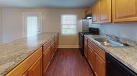 Located at 248 Presidential Dr in Wilmington, Delaware, this single-floor residence offers a straightforward and functional layout designed for comfortable everyday living. The living areas are finished with neutral-toned wall-to-wall carpeting, creating a warm and cohesive feel throughout. Natural light filters in through multiple windows fitted with blinds, brightening the generously sized rooms.

The kitchen is a practical and well-appointed space, featuring warm honey-toned cabinetry with raised-panel doors, granite-look countertops, and rich hardwood-style flooring. Black appliances — including a range, dishwasher, and full-size refrigerator — are included, along with a built-in range hood. A door in the kitchen provides convenient exterior access.

The bedrooms are comfortably sized, each with plush carpeting, ceiling fans, and windows that allow for natural light and views of the surroundings. The floor plan also reveals a spacious open living and dining area connected by a wide pass-through opening.

Two bathrooms serve the residence: one features white subway tile walling, a soaking tub, and hardwood-style flooring with a window for ventilation; the other is a clean, compact bathroom with tile flooring, a white vanity, and a well-lit mirror cabinet. The overall aesthetic is clean, neutral, and move-in ready.